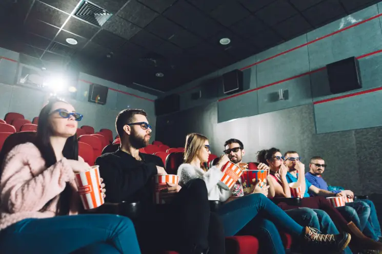 A group of people watching a movie in a cinema, illustrating the power of the target audience in film marketing