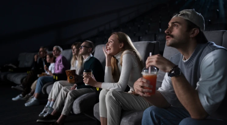 a group of people watching a movie trailer in a theater